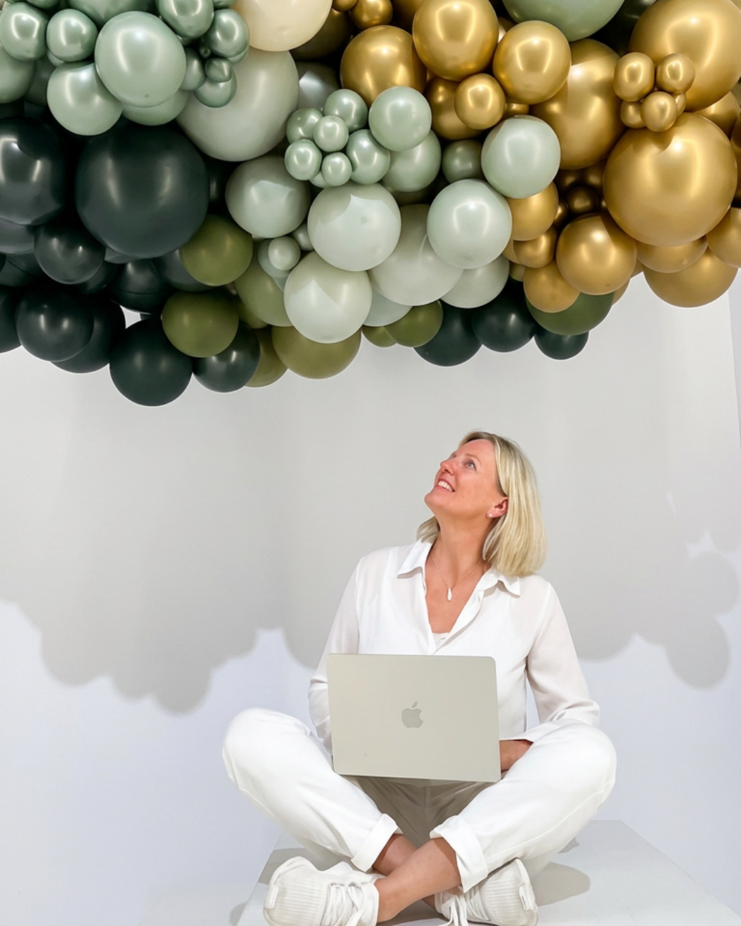 Olga Reyes-Busch schaut hoffnungsvoll nach oben zu einer Ballon-Wolke